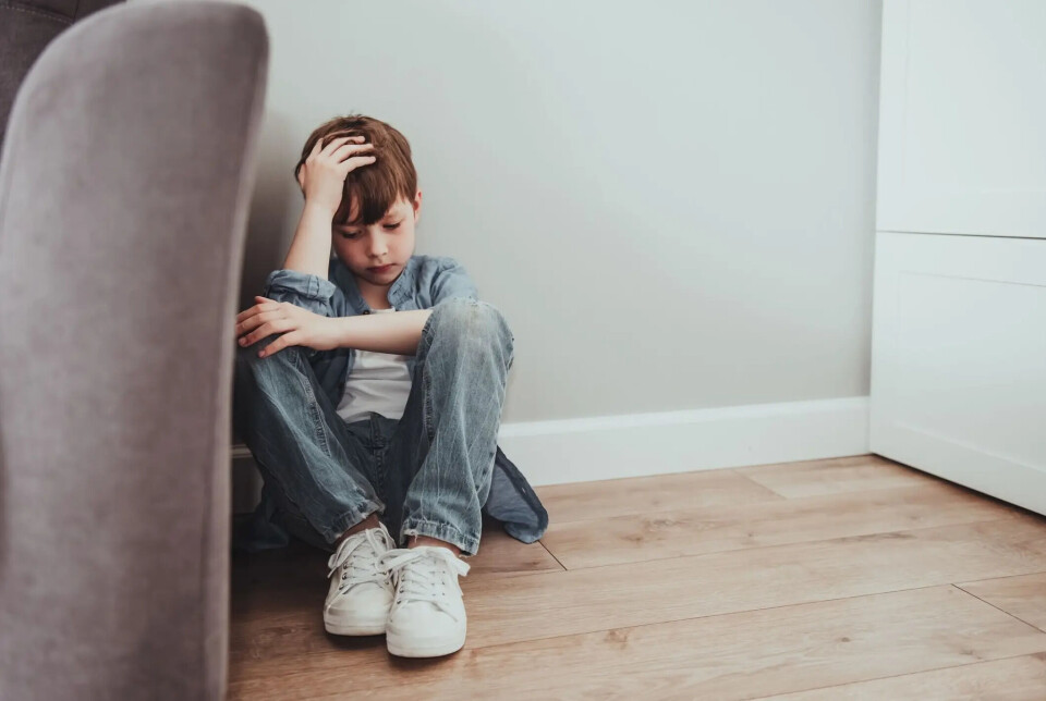 Child welfare services do not have guidelines for conversations with children that ensure they are heard. A young boy sits on the ground beside a sofa looking dejected.