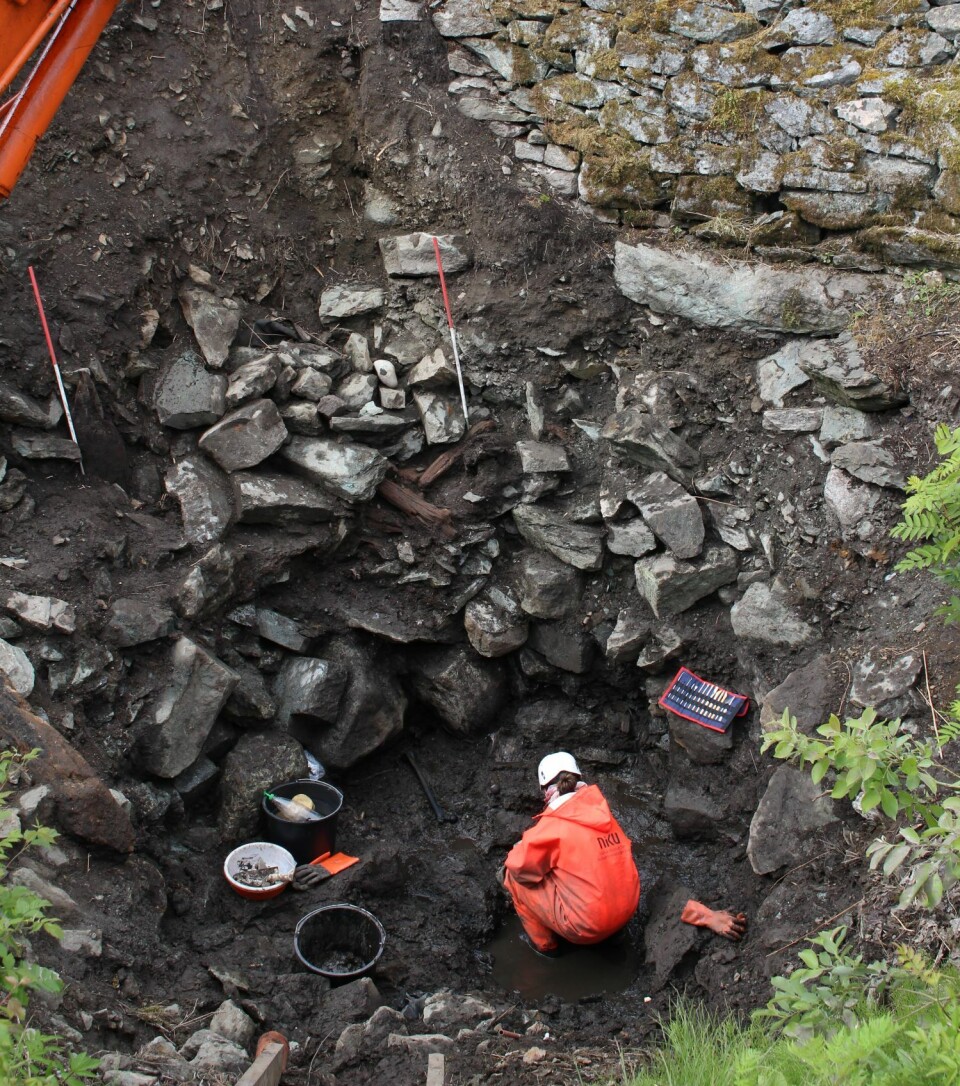 From the excavation. Osteoarchaeologist Hanne Ekstrøm Jordahl collects human remains at the bottom of the well. Arkeologer som graver