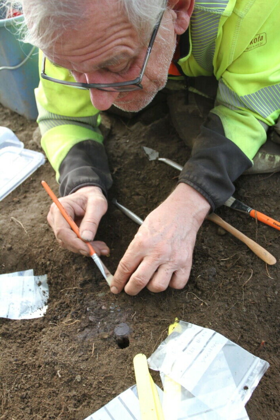 Archaeologist and project leader for the excavation, Søren Diinhoff, in the process of carefully extracting silver coins from the ground.