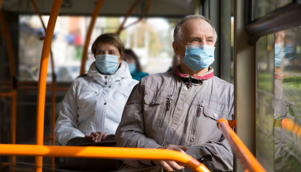 Vaccinated individuals had a lower mortality rate than those who were not vaccinated during the period from 2021 to 2023. Eldre mann og eldre kvinne med munnbind sitter på buss.