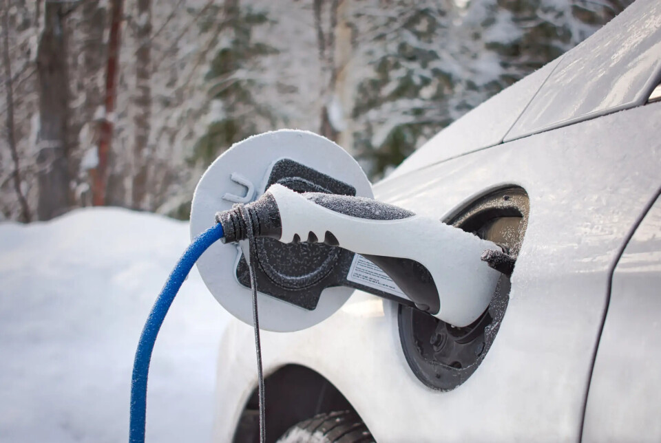 Critical minerals are important for green technology, such as electric cars, wind turbines, and mobile phones. A white electric car being charged in the snow.