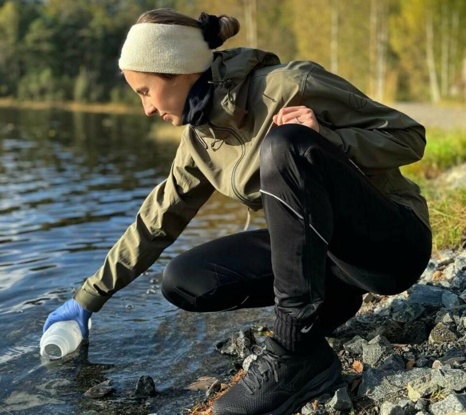 Silje Halvorsen takes a water sample from the freshwater lake Gillsvannet.