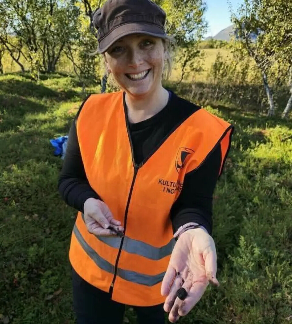 Stine Grøvdal Melsæther holds up charcoal found in a firepit within the house foundation where the archaeologists conducted a test excavation.