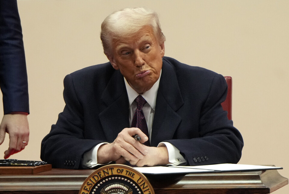 Donald Trump signs executive orders during his inauguration on January 20. Donald Trump gjør en grimase mens han signerer dokumenter.