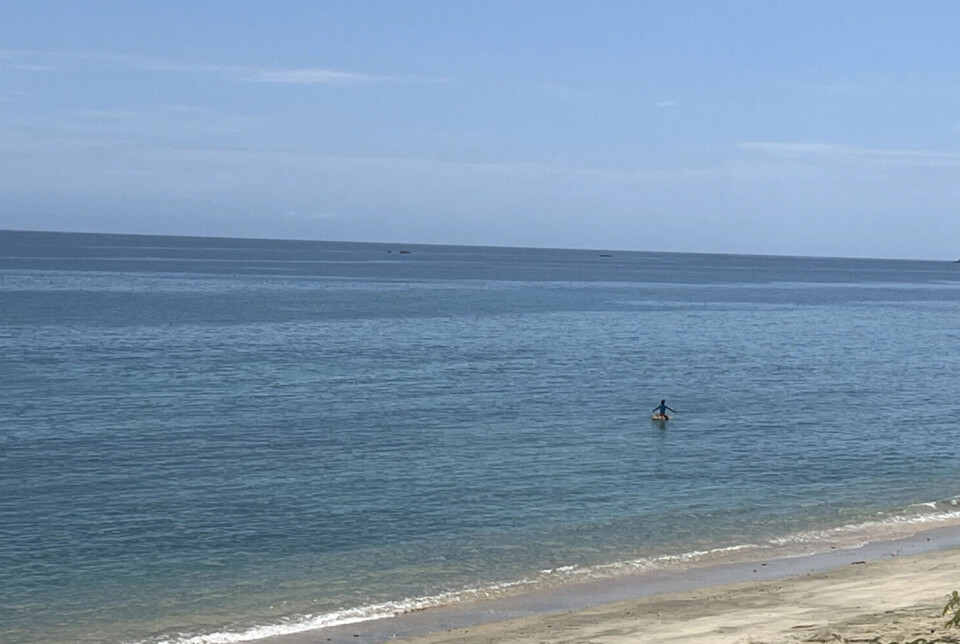 A young fisherman working from a small raft.