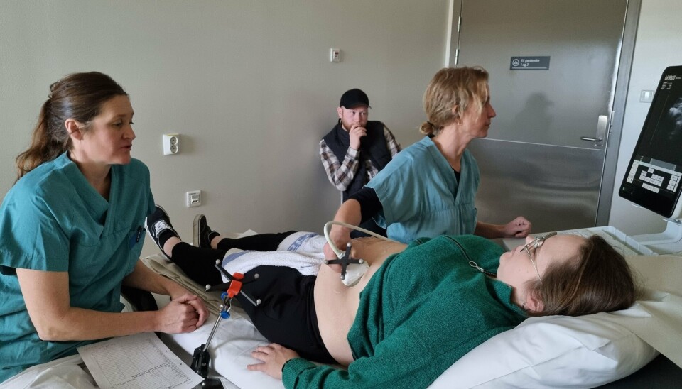 Karianne Sagberg explains the research project to Karoline Haugsjordet and Erlend Holten while Helene Peterson performs the ultrasound examination.