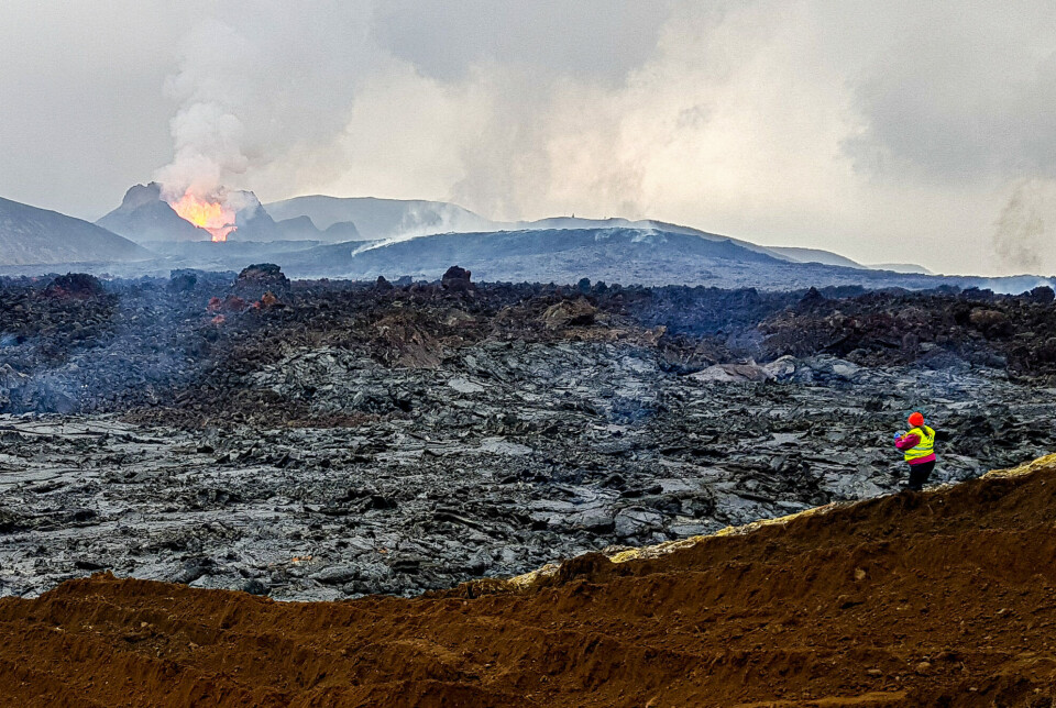 May 20, 2021. Fjóla Guðrún Sigtryggsdóttir is shown studying the lava field upstream of the dams, with the Fagradalsfjall volcano in the background. 20. mai 2021. Fjóla Guðrún Sigtryggsdóttir undersøker lavafeltet oppstrøms for demningene. Fagradalsfjall-vulkanen i bakgrunnen