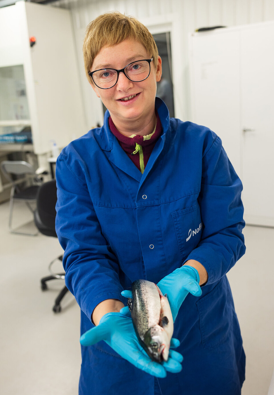 Trine Ytrestøyl has researched salmon and how stress combined with different feeds affects its red colour. The fish in the photo was not part of the research. Trine Ytrestøyl viser en fisk - som ikke en del av forskningen.