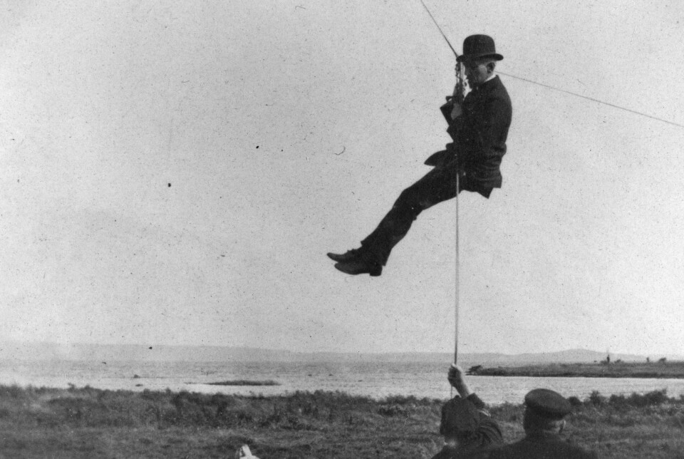 Roald Amundsen testing equipment to allow him to search for leads from the air above the ship Fram.