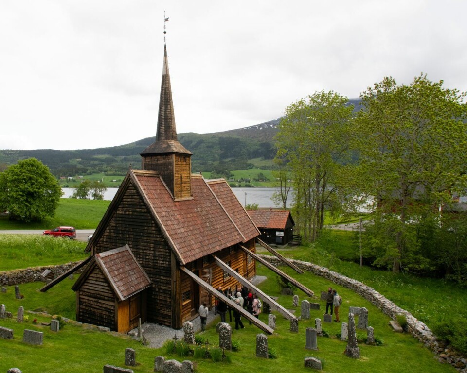 Rødven Stave Church is clad in wooden boards, behind which the portal is usually concealed. The church was recently examined, and the portal was uncovered. Rødven stavkirke med kirkegården rundt.