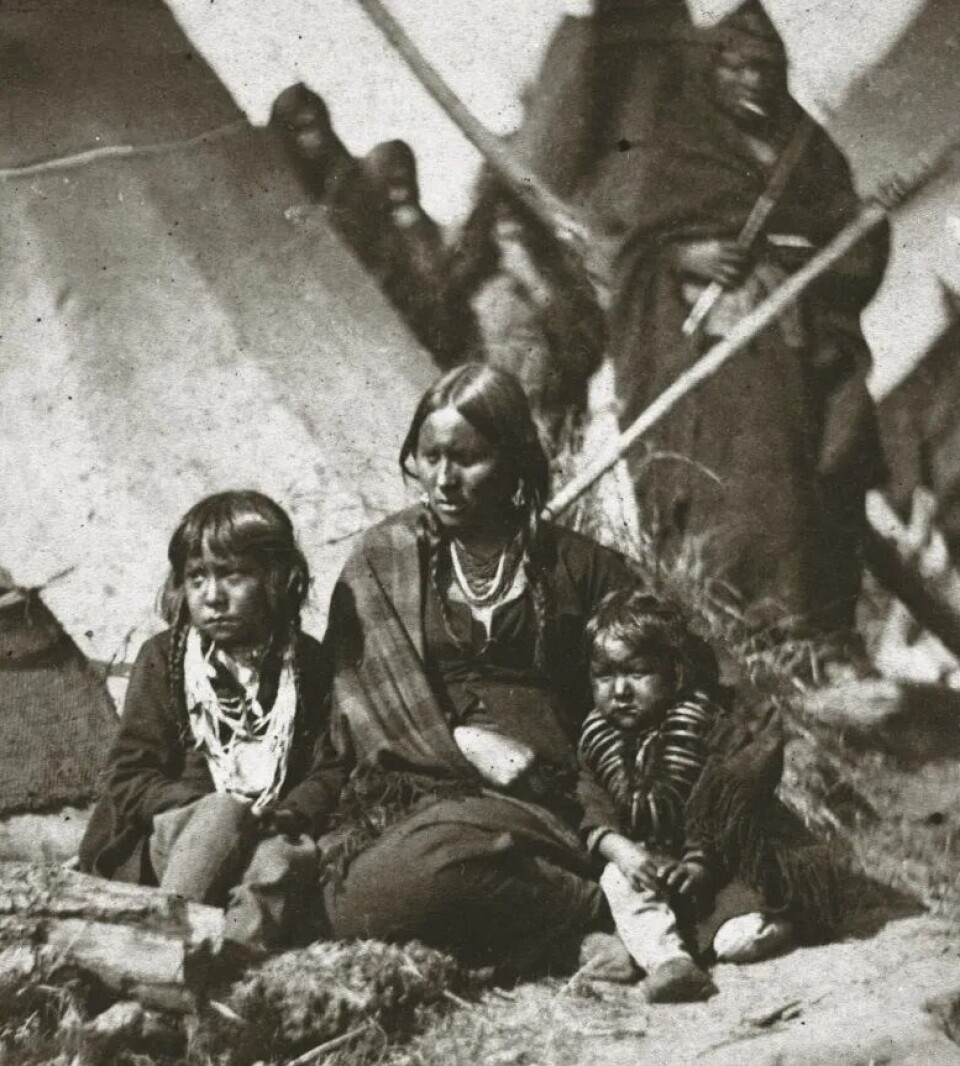 Chief Little Crow's wife and two children in the prison camp at Fort Snelling. Little Crow himself escaped but was shot by a settler a few years later. Kvinne av dakotafolket med to barn.