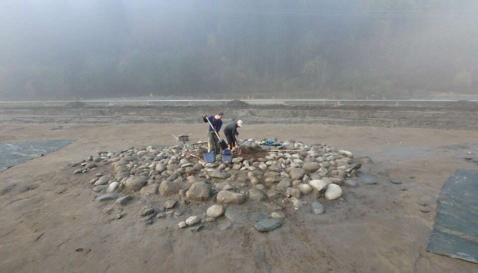 Excavation of the burial cairn, where archaeologists found a stone with a cup mark and a pecked footprint.