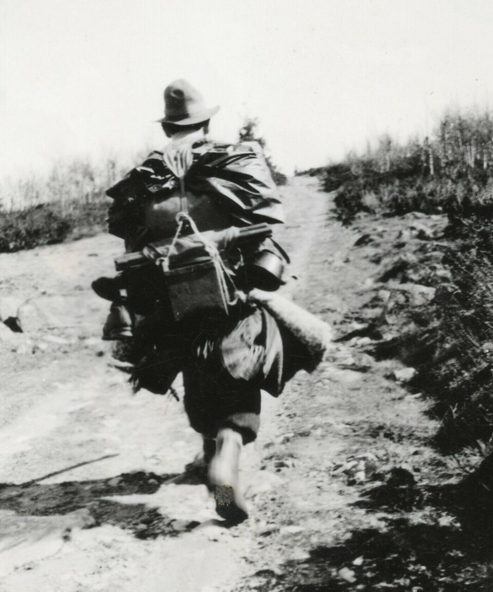 A street vendor carrying his goods on his back.
