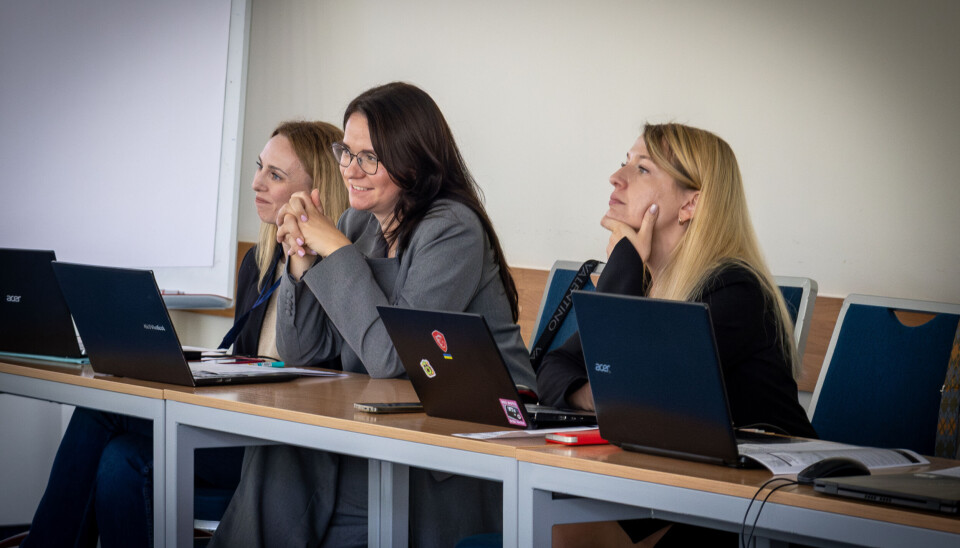 Kateryna Maksom (to the right) at the TURBO Conference. Three women sat behind laptops.