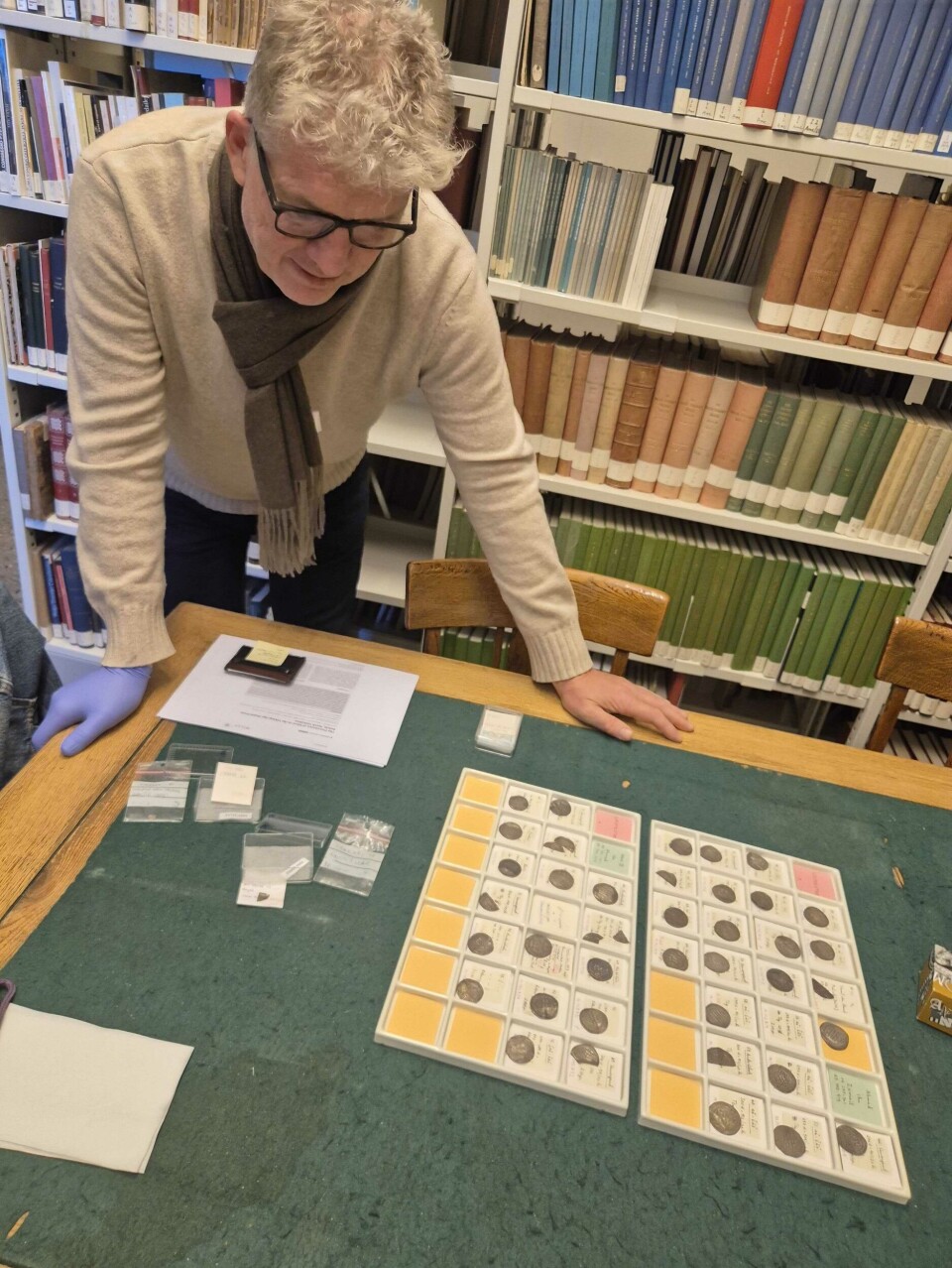 Svein H. Gullbekk looks at a tray of dirhams.