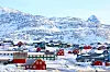 Colourful snow-covered houses in Nuuk beneath icy mountain slopes