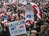 Demonstrators in Copenhagen hold Greenlandic and Danish flags with protest signs in a crowded square