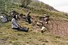 Older photo fo a family planting potatoes on a hillside field.