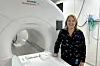 Woman stands by an MRI machine