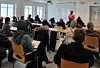 Students sit in a classroom in Norway listening to an instructor at the whiteboard.