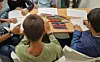 Children sat around a table drawing with coloured pencils