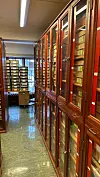 Wooden glass-door cabinets and archive boxes filling a narrow storage aisle