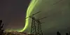 Green aurora above a power line in northern Norway at night
