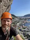 Selfie of man climbing the mountains with an orange helmet