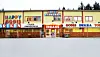 Colourful candy factory building with bold signs and empty parking area near Svinesund.
