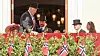 Norwegian royal family on palace balcony above rows of Norwegian flags