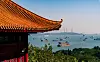 Traditional Chinese pavilion roof overlooking a busy bay with cargo ships