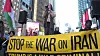 Protesters display a yellow 'Stop the war on Iran' banner in a city demonstration