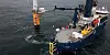 Electric service boat alongside a wind turbine in open water during offshore charging.