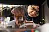 Giuseppe Guidi looks closely at a charging plug prototype on a workbench.