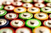 Close-up of multiple colourful batteries showing their positive terminals