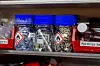 Plastic jars with blue lids on a workshop storage shelf