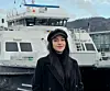 Woman standing in front of a passenger ferry