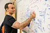 Jacob Linder writing equations on a whiteboard.
