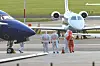 Medics walk beside a patient on the airport tarmac near a medevac plane at Schiphol.