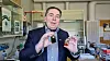Man holding two small objects up to the camera.