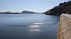 Concrete dam beside a wide artificial lake with distant hills and a wooded shoreline in Zimbabwe.