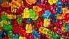 Close-up of assorted brightly coloured gummy sweets piled together.