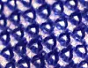 Close-up microscopic view of blue dress fabric threads woven into a knit pattern.