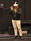 Pedro wears a VR headset and gestures with his hands in a dark studio.