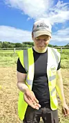 Kristoffer Hillesland holding a weight in his hand out in the field.