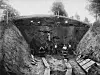 1939 excavation at Raknehaugen showing workers in a deep trench with timber planks and steep earth sides.