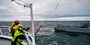 Norwegian Coast Guard and Bergen Fire Department crew members launch a towline during an at-sea towing drill.