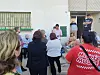 People seated and standing in a courtyard during a neighbourhood meeting in Bogotá.