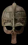 Weathered bronze helmet with a feather crest on a black background.
