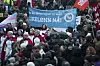 Crowd at an International Women’s Day rally in Oslo holding banners and flags.
